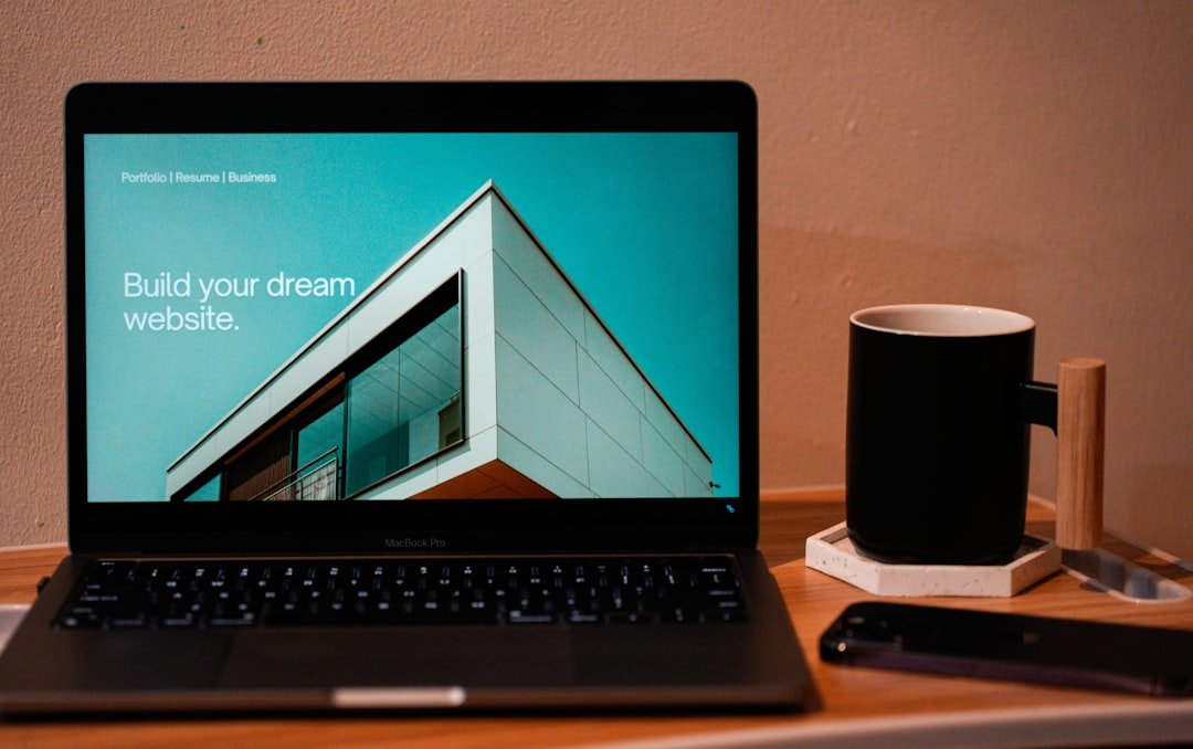 Home Build your dream website for your future. A laptop, MacBook, on top of a portable table with coffee tea mug on the side.